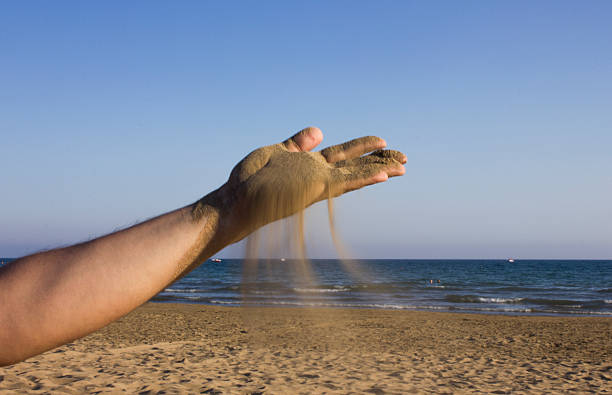 istock Sea sand flowing through a mans hands 502417639