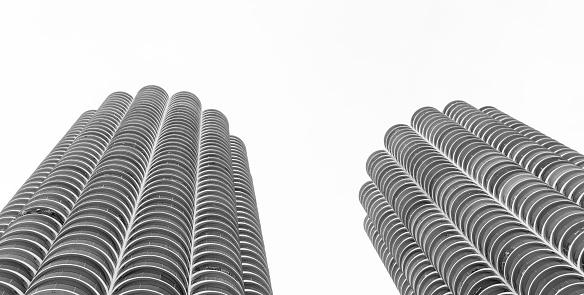 Close-up on a tall city office building with cloudy sky beyond.