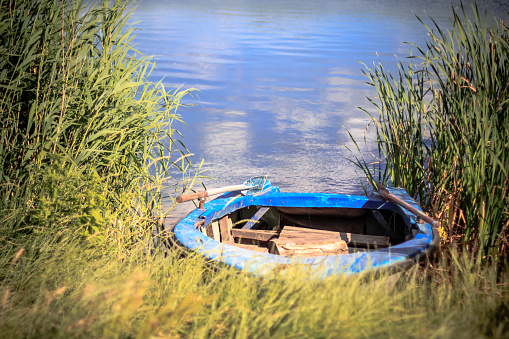 Old wooden rowboat on the shore of a river
