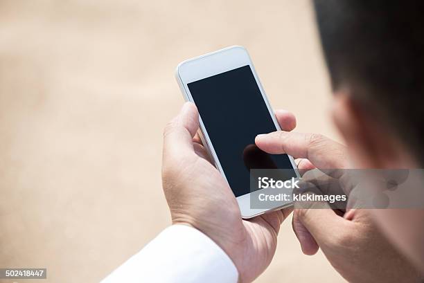 Hombre Usando Teléfono Inteligente Foto de stock y más banco de imágenes de Mirar por encima del hombro - Mirar por encima del hombro, Hombres, Teléfono