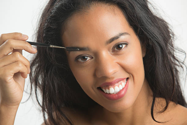 Happy woman combing her eyebrows, with eyebrow brush. Happy woman combing her eyebrows, with eyebrow brush. make over series stock pictures, royalty-free photos & images