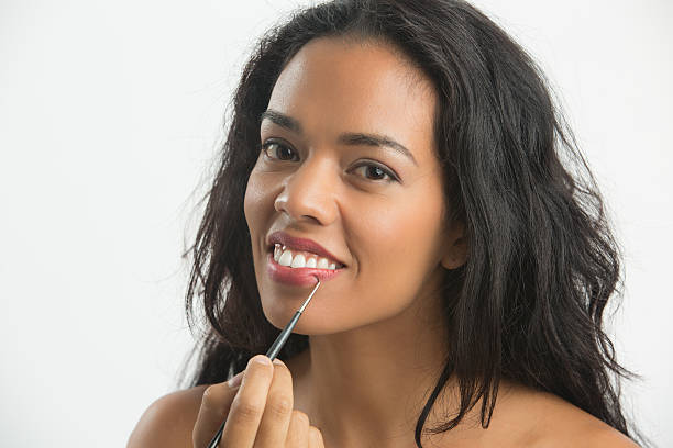istock Happy woman applying makeup lips with a brush 502419672