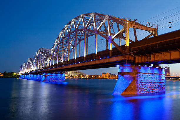 ponte ferroviario di notte, riga, lettonia - daugava river foto e immagini stock