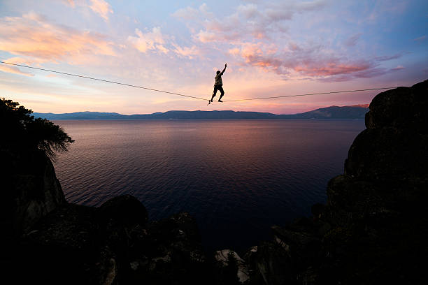 achievment Slacklining in a dramatic setting over Lake Tahoe tightrope stock pictures, royalty-free photos & images