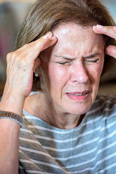 sênior mulher com dor - senior women defeat headache frustration - fotografias e filmes do acervo