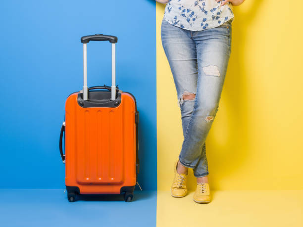 istock Woman stands beside suitcase 502424542