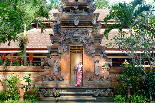 Bali, Indonesia-September 19, 2014:Tourist giving a post in one of the small temple in district Ubud during the religious ceremony.