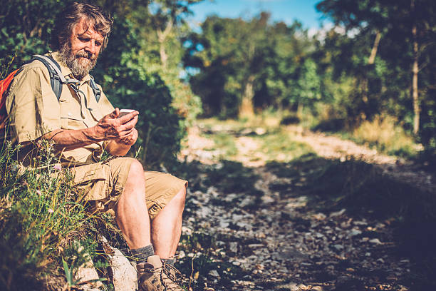 istock Senior Man with Beard Surfing while Hiking in Forest 502426702