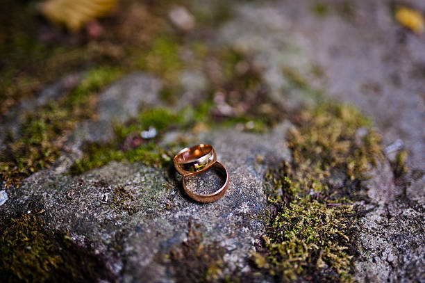 istock Wedding rings at stone with moss 502448078