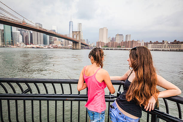 istock Two girls, sisters, looking to Manhattan under thunderstorm 502449689