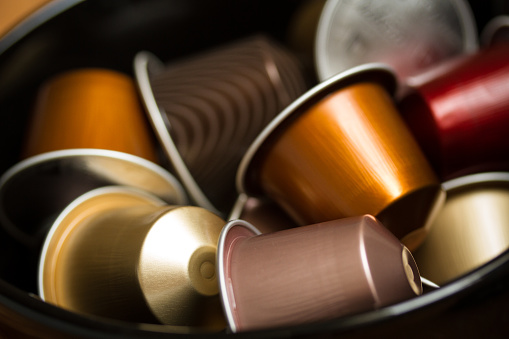 Copenhagen, Denmark - July 8, 2014: Close up shot of black bowl with different colored Nespresso capsules. Selective focus on foreground.