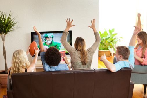 Grupo de amigos mirando juntos y alentar juego de fútbol americano photo