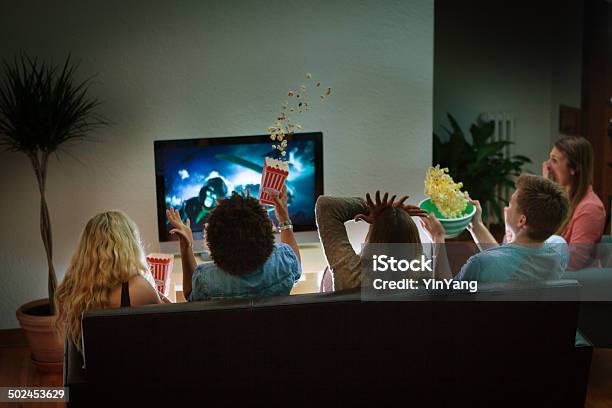 Group Of Friends Watching Halloween Scary Movie Together At Home Stock Photo - Download Image Now