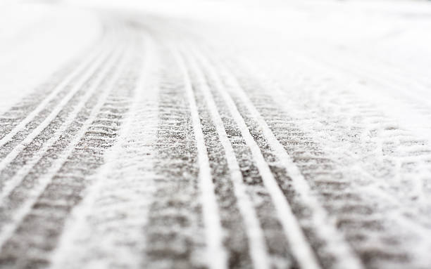 Wheel tracks on the road covered with snow stock photo