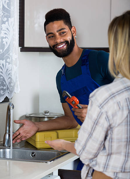 istock plumber and housewife in kitchen 502458416