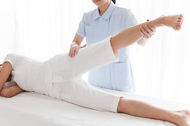 istock Woman lying forward while a physiotherapist examining her leg 502462108
