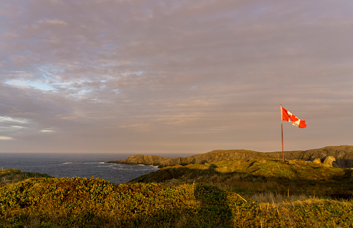 The well known maple leaf of the Canadian Flag is beautifully accentuated by the sunset on and island off the coast of Newfoundland, Quirpon Island.