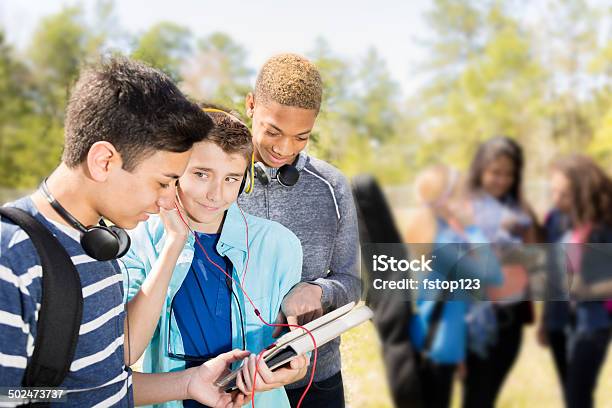 Music Teenage Friends Listen To Music On Digital Tablet Park Stock Photo - Download Image Now