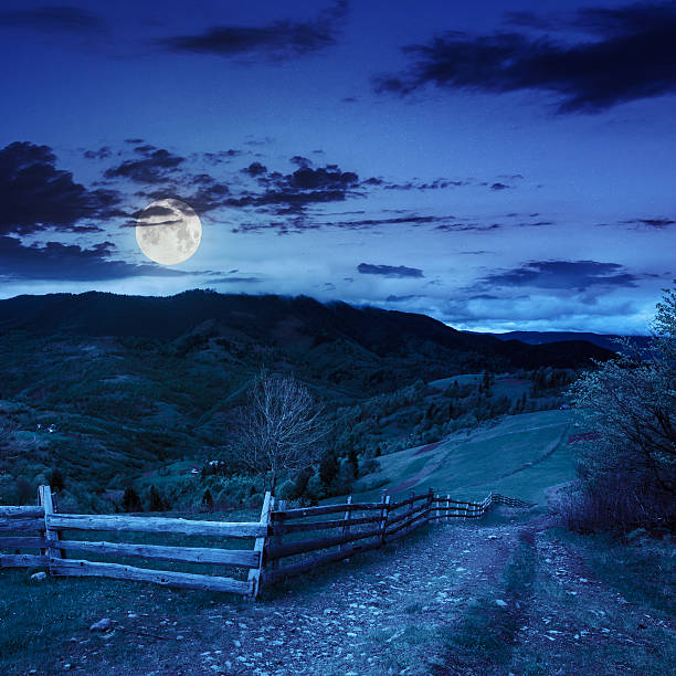istock fence on hillside meadow in mountain at night 502473763