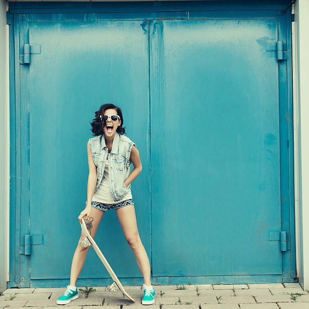 Young brunette woman posing with skateboard