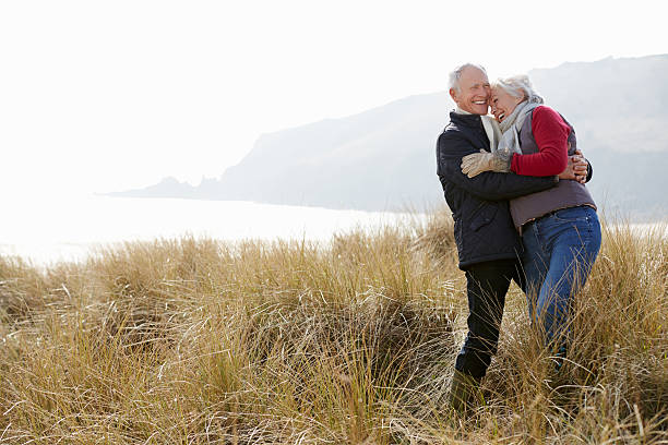 istock Senior Couple Walking Through Sand Dunes On Winter Beach 502474833