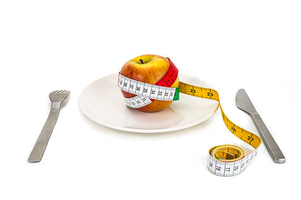 ernährung - healthy eating fork tape measure still life stock-fotos und bilder