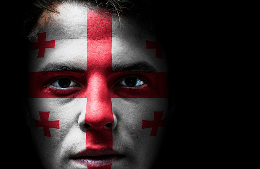 Georgia, Georgian flag on face, isolated on black background. Nationalist and nationalism concept