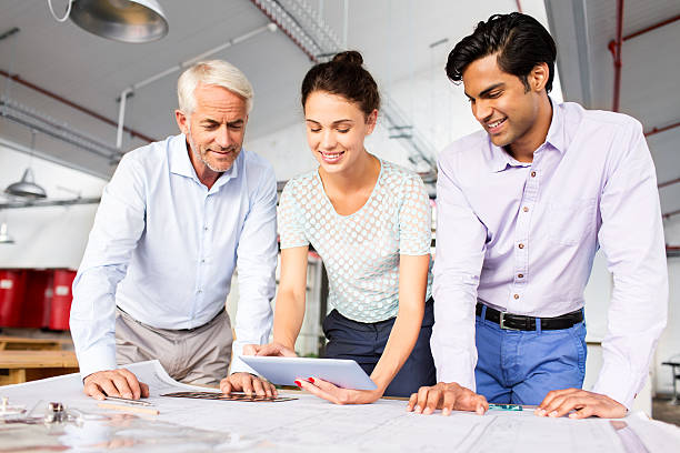istock Architects Discussing Over Digital Tablet With Blueprint At Desk 502478707