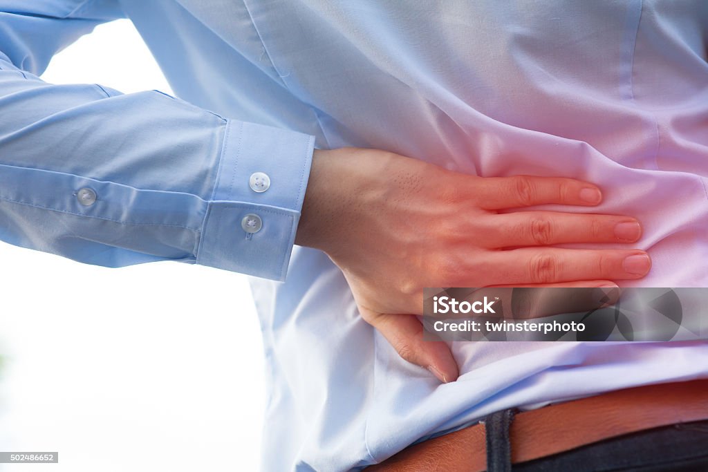 Man in office uniform having back pain / back injury Man in office uniform having back pain issue / back injury Human Bone Stock Photo