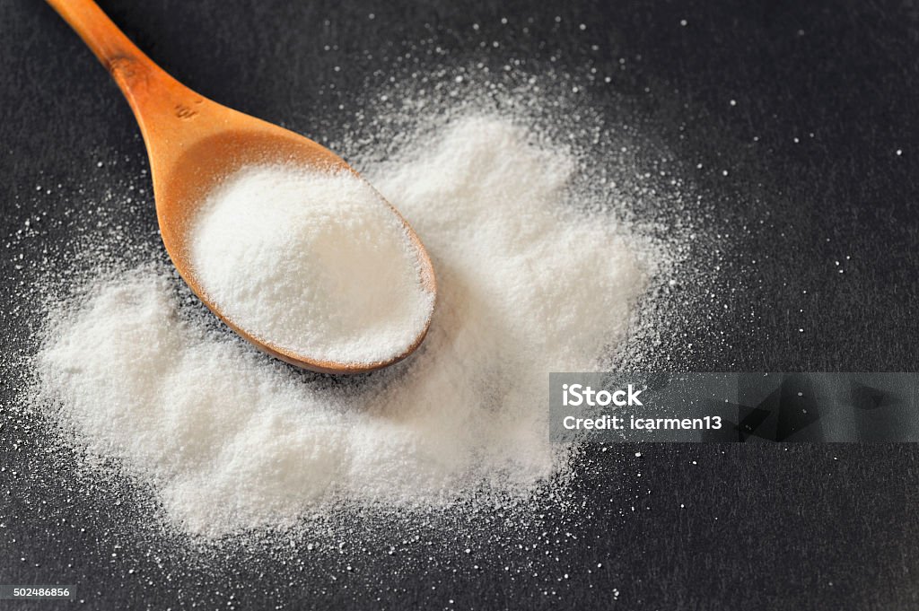 Bicarbonate in a wooden spoon Bicarbonate in a wooden spoon on black background 2015 Stock Photo