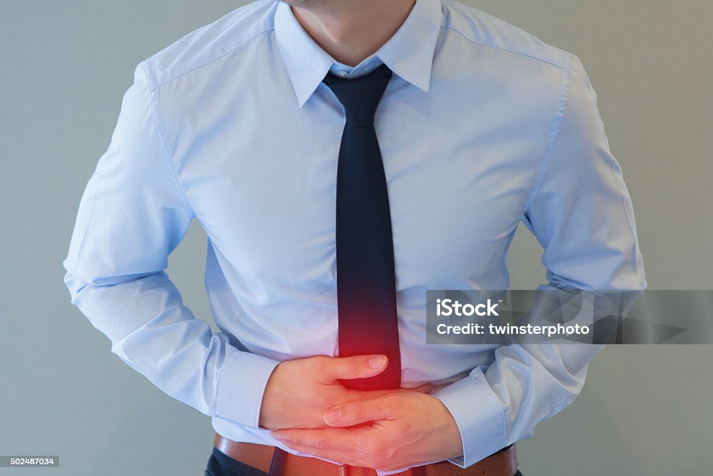 Mann im Büro-Outfit einen Bauchschmerzen - Lizenzfrei Bauchschmerzen Stock-Foto