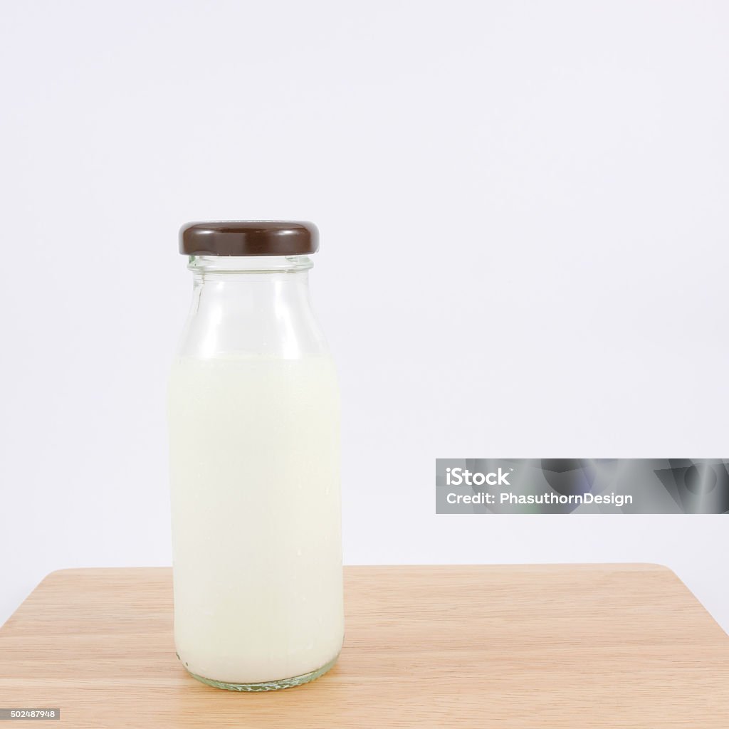 The bottle of fresh milk The bottle of fresh milk on the wooden board. 2015 Stock Photo