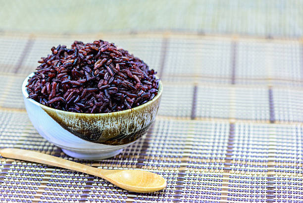 istock Brown rice in bowl with wooden spoon. 502489306