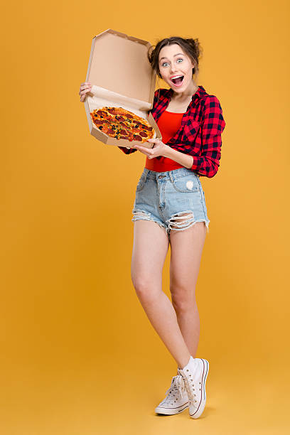 istock Funny joyful young woman standing and posing with pizza 502496736