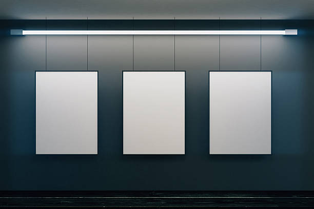 Blank picture frames on grey wall with glowing lamp