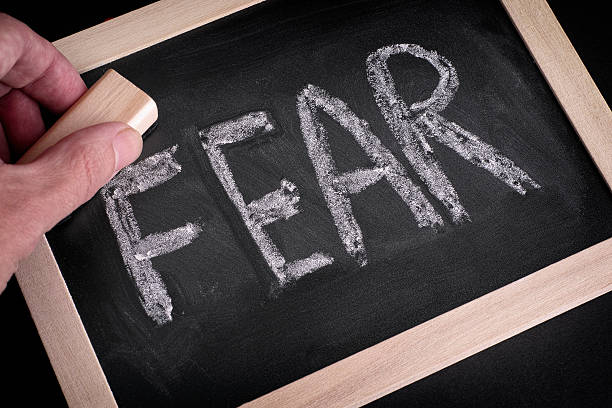istock Hand erasing the word Fear on chalkboard 502498144