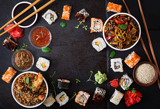 Traditional Japanese food Traditional Japanese food - sushi, rolls, rice with shrimp and udon noodles with chicken and mushrooms on a dark background. Top view japanese food stock pictures, royalty-free photos & images