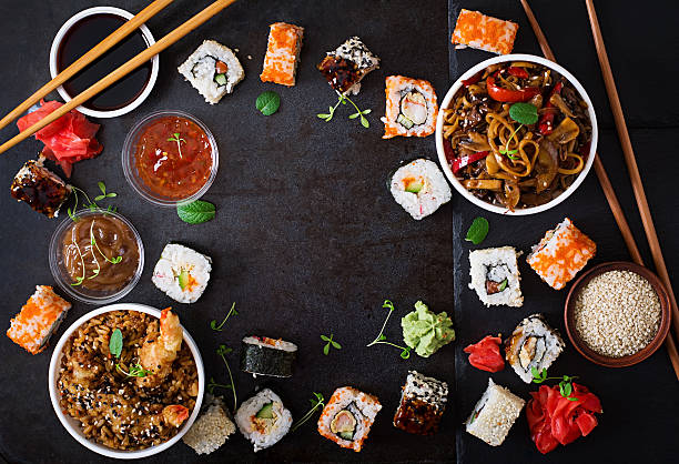 Traditional Japanese food Traditional Japanese food - sushi, rolls, rice with shrimp and udon noodles with chicken and mushrooms on a dark background. Top view wasabi sauce stock pictures, royalty-free photos & images