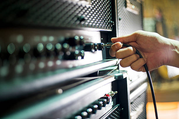istock Closed up hand holding jack plug-in to the guitar amplifier 502517876
