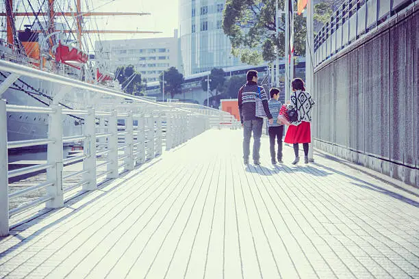 Photo of Three people of family walking bayside walk