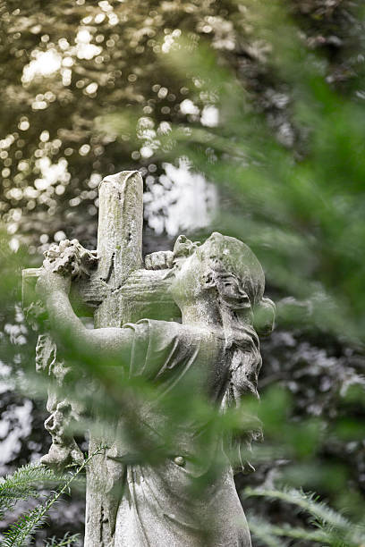 istock Maria with cross sculpture hidden behind some leaves 502518844