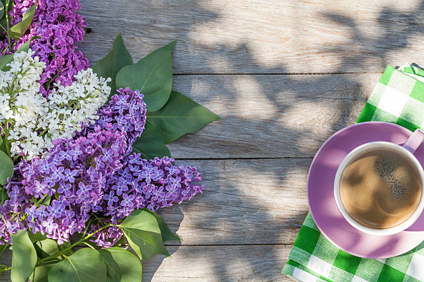istock Coffee cup and colorful lilac flowers on garden table 502520438