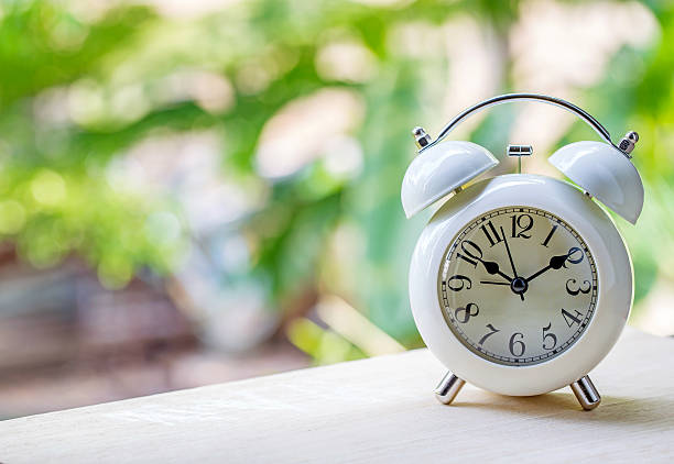 istock alarm clock on table with green background. 502523600