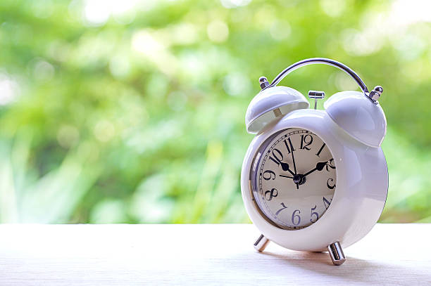 istock alarm clock on table with green background. 502523940