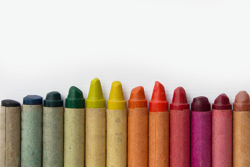 group of old wax crayons on white paper - vintage crayons many colors