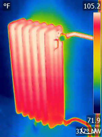 Thermal image of a home radiator. Colors represent various temperatures, defined with rainbow Fahrenheit scale on right side of image. Photo is taken with Flir T420 infrared camera.