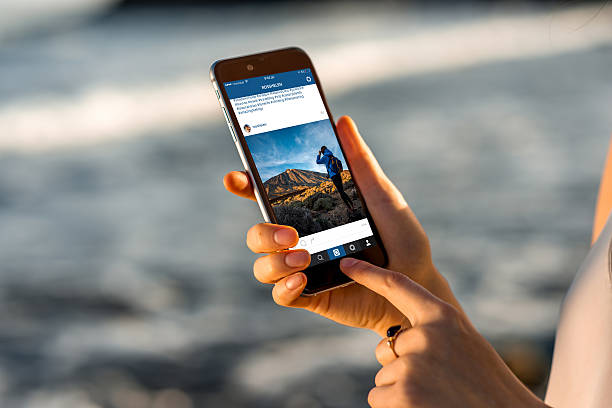 mujer mirando instagram noticias con new iphone - tenerife spain national park canary islands fotografías e imágenes de stock