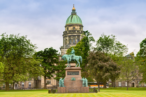 Edinburgh, United Kingdom - June 22, 2015: Charlotte Square, Edinburgh, Scotland, United Kingdom.  I the center of the image is an equestrian statue of the Prince Albert, the consort of Queen Victoria, in field marshal's uniform. It was unveiled by Queen Victoria herself in 1876. Canon EF 24-105 mm f/4L lens. HDR photorealistic image. Green trees, historic church and sky with clouds are in background.