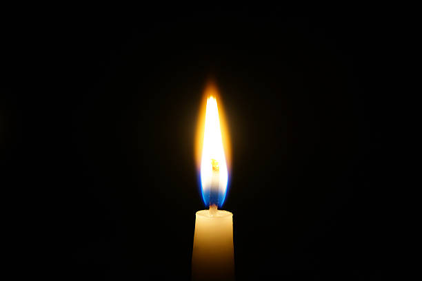 istock burning candle isolated on black 502551560