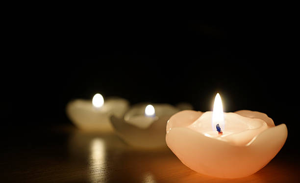 istock burning candle isolated on black 502551888